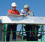 Two workers looking at plans